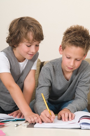 Two friends doing their homework in the livingroomの写真素材