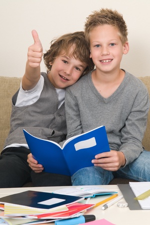 Two friends doing their homework in the livingroomの写真素材
