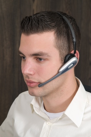 Male receptionist working at a helpdesk in an officeの写真素材