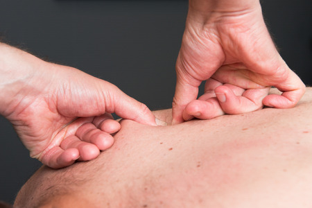 Massage therapist is working with a clientの写真素材