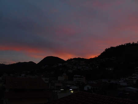 Mountains at dusk, with reddish sun rays reflected by clouds. Mountains at dusk, with reddish sun rays reflected by the clouds.の写真素材