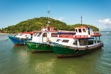 Tourist transport boats moored near a beach. Painted in bright colors, advertise the different companies that operate them.のeditorial素材