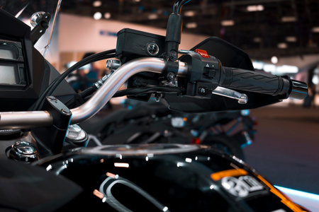 Motorcycle handlebar assembly with hydraulic lever, electrical controls, brake fluid reservoir, and...