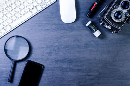top view of work space photographer with vintage camera, mobile, computer keyboard, mouse and magnifying glass on wooden background.の写真素材