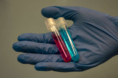 Hand holding tubes with colorful liquid