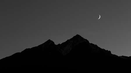 Moon over dark mountain silhouette