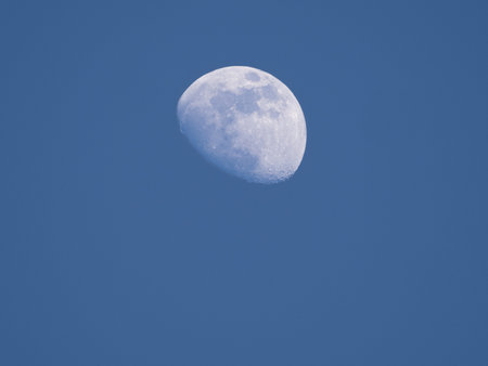 Crescent moon during sunset with blue sky