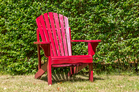 red wooden chair against a green backgroundの写真素材