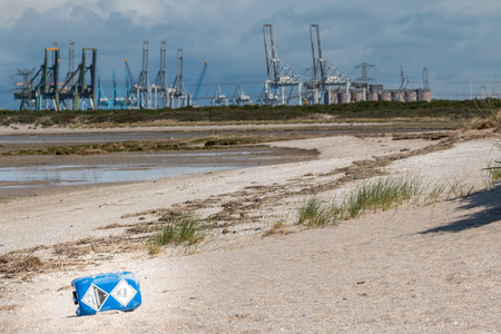 trash on the beach with cranes in the backgroundの写真素材