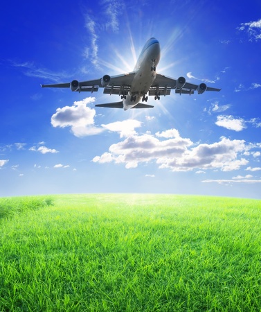 Airplane fly over grassの写真素材