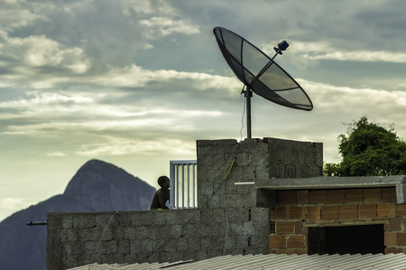 Boy watching tv in Favela  slums  in Rio de Janeiro  in Rio de Janeiro の写真素材