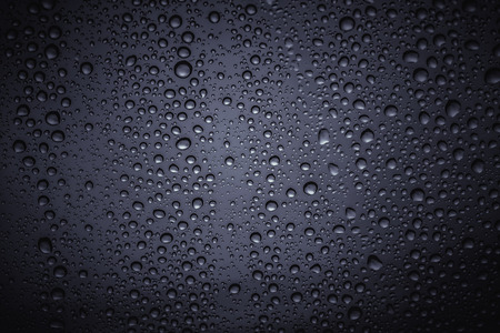 Water droplets on the glass with a colored backgroundの写真素材