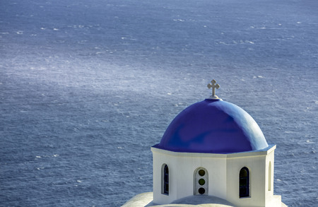 Santorini Island with traditional blue dome church against the sea, Greeceの写真素材