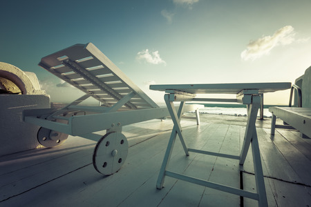 Wooden sunbed with table at the infinity pool. Vacation conceptの写真素材