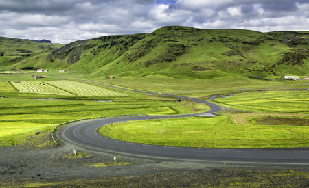 Icelandic mountain landscapes with curved asphalt roadの写真素材
