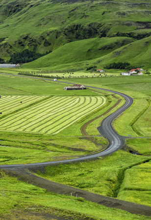 Icelandic mountain landscapes with curved asphalt roadの写真素材