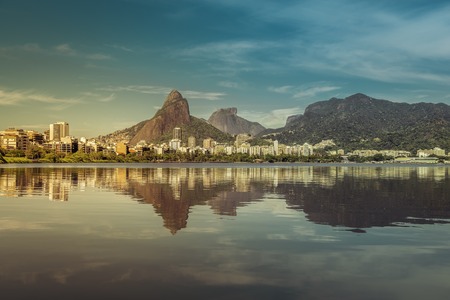 Sunrise over mountains in Rio de Janeiro with water reflection and light leak, Brazilの写真素材