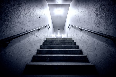 Underground passage with stairs going up at nightの写真素材