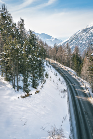 Asphalt curved road in high Alp mountains, winter seasonの写真素材