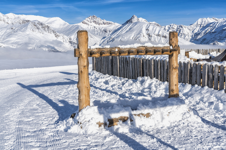 Wooden snowboard holder, high mountains peaks as background. Winter seasonの写真素材