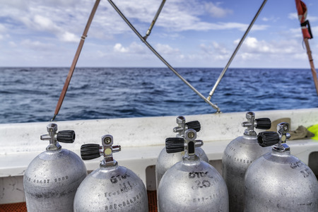 Scuba diving air tanks on the boat, ocean with horizonの写真素材