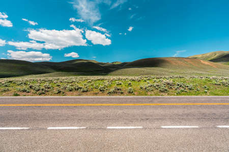 Asphalt empty road with hills and blue skyの写真素材