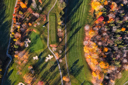 Aerial top down view of golf course, fall season, colorful trees