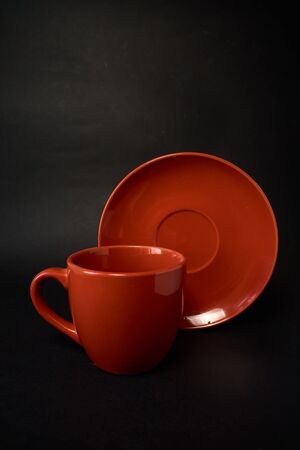 Red cup of coffee and saucer on a black backgroundの写真素材