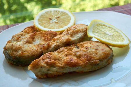 Pieces of fried fish with lemon wedges.の写真素材