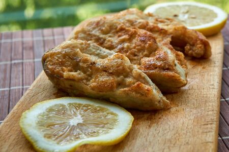 Pieces of fried fish with lemon wedges