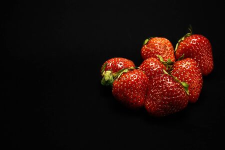 red strawberries on a black background, black isolate, close-upの写真素材