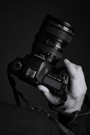 Ukraine 04 2019. Camera in hand, photographer, photographing, black-and-white, editorial.
