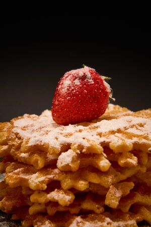 Crispy sweet waffles with fresh strawberries, on a dark backgroundの写真素材