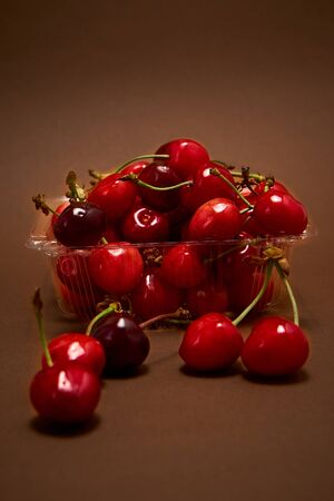 Tray with fresh cherry on a brown background