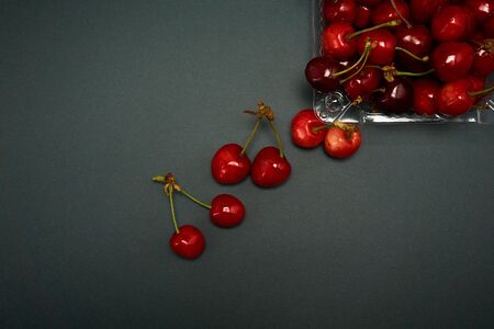 Tray with fresh cherry on a gray background