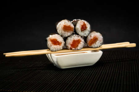 Shiake Maki roll lies on sticks on a black backgroundの写真素材
