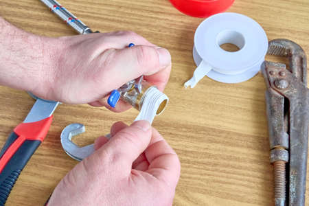 Man winding fum tape on a ball-type water tap.の写真素材