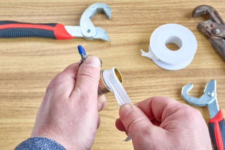 Man winding fum tape on a ball-type water tap.の写真素材