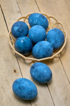 Blue painted eggs on a wooden background, vertical shot, vertical orientation.の写真素材