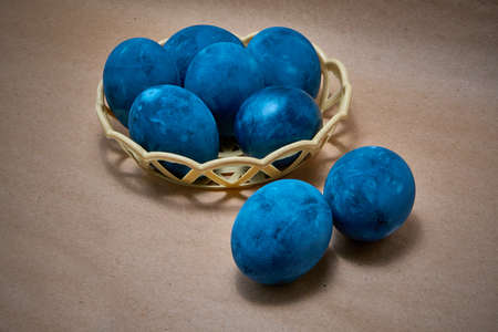 Blue painted eggs on paper background.