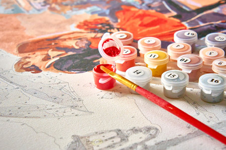 Painting for beginners. A set of numbered acrylic paints, a brush and a canvas with numbers for painting a painting by numbers. Self-isolation, creative leisureの写真素材