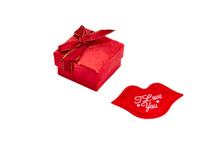 Red gift box with red ribbon bow with gold border on lid for ring or jewelry, with decorative kiss with I love you on white background, Valentine's Day.の写真素材
