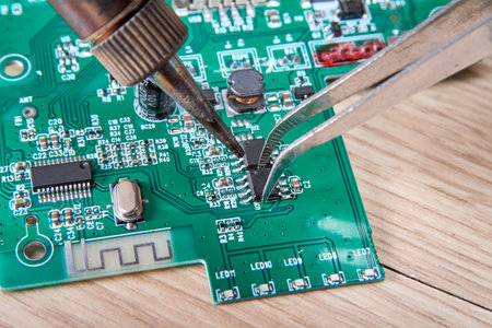 Electronic circuit board repair by replacing the damaged part with a soldering iron, electronic circuit board repair with soldering iron and tin wire, computer equipment, mobile phone, electronics, repair, upgrade and technology repair concept.の写真素材