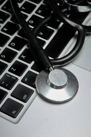 Medical stethoscope lies on the keyboard of a portable computerの写真素材