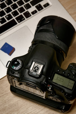 Digital SLR camera and laptop, top view.