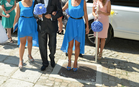 romanian traditional wedding. groom together with the bridesmaids are walking on the village roadsの写真素材