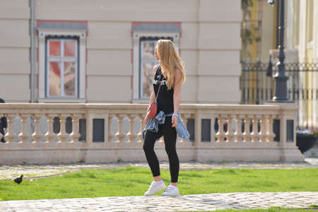 TIMISOARA, ROMANIA - March 15, 2018, Piata Unirii square: blonde girl dressed in black is walking on the streetのeditorial素材