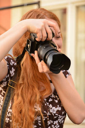 TIMISOARA, ROMANIA - April 27, 2013: portrait of a redhead woman photographerのeditorial素材