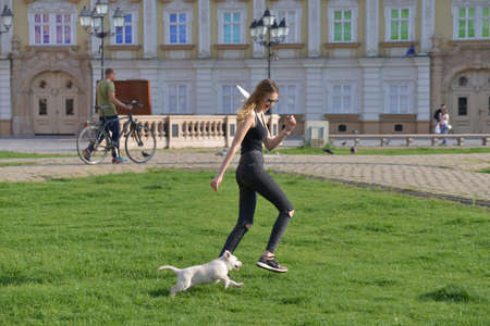 TIMISOARA, ROMANIA - April 24, 2018: a teenager girl is walking a dog on the street