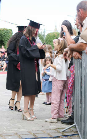TIMISOARA, ROMANIA - June 09, 2019: university graduating students are having a photo shooting in the parkのeditorial素材